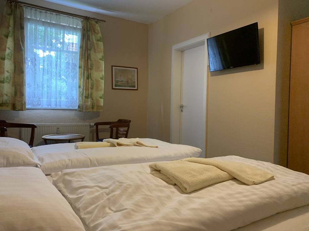 Helles Doppelzimmer mit TV und Sitzgelegenheit