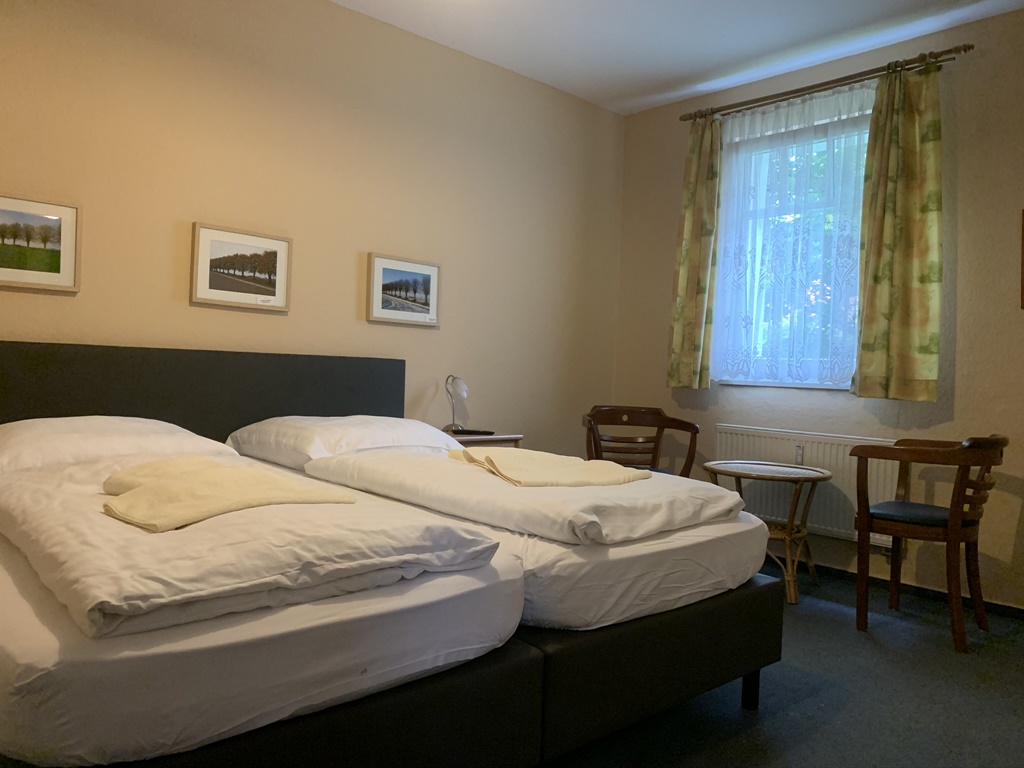Doppelzimmer mit Fenster und Sitzgelegenheit