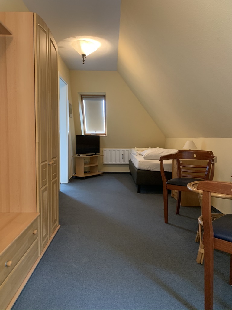 Einzelzimmer mit Schrank und TV
